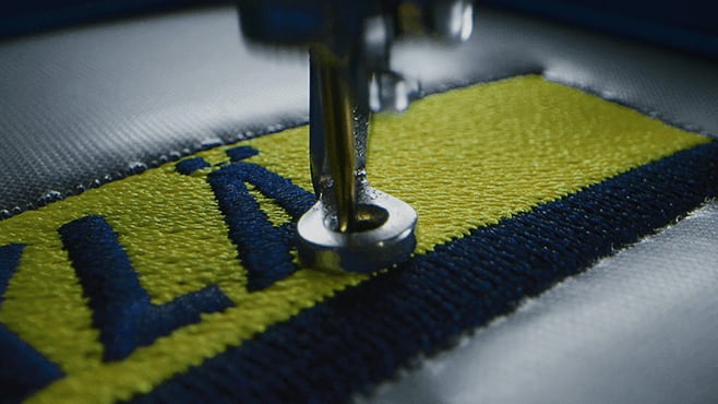 Stickmaschine, die ein Logo auf Arbeitskleidung stickt